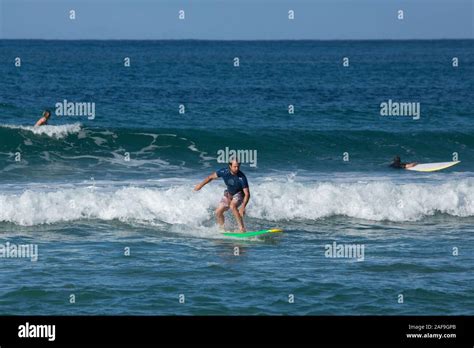 A tourist catches a wave surfing in Hanalei Bay, Kauai, Hawaii Stock ...