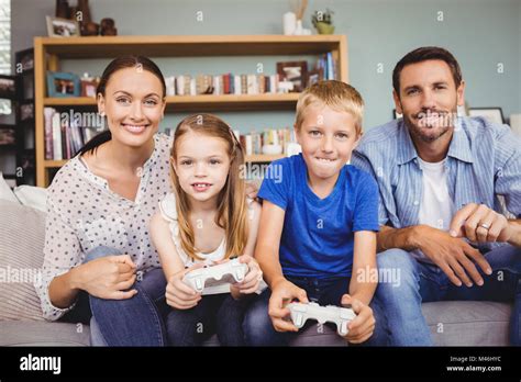 Smiling children playing video games with parents Stock Photo - Alamy