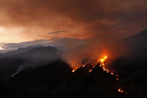 A wildfire burns the hillside during sunset in the Angeles National Forest near Glendora ...