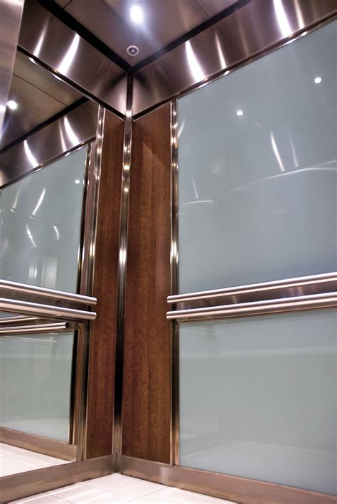 The rear wall of this Elevator Interior is fitted with back painted safety glass above and below ...
