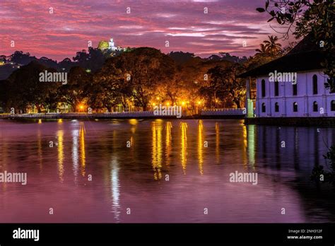 Night time view of The lake in central Kandy in the hill country of Sri Lanka, with large Buddha ...