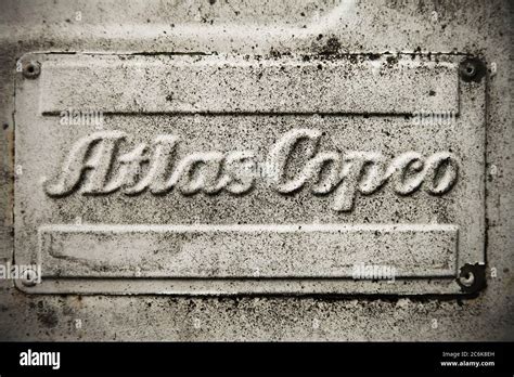 "Atlas Copco" logo on old dirty white panel Stock Photo - Alamy