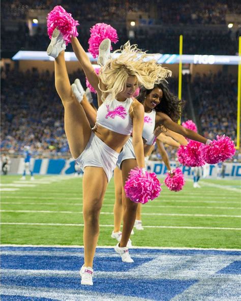 two cheerleaders perform on the field during a football game