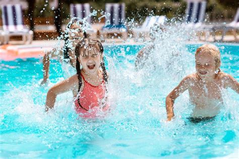 Children Laughing while Splashing Water in Swimming Pool Stock Image ...