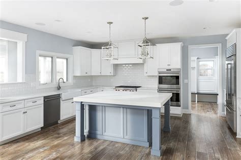 White cabinets and blue/gray island combine for a casual elegance in this custom-built home by ...