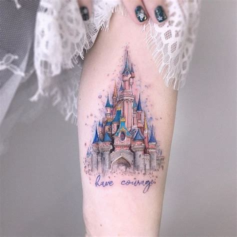 a woman's leg with a disney castle tattoo on her left thigh and the ...