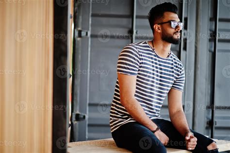 Handsome tall arabian beard man model at stripped shirt posed outdoor ...