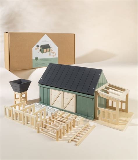 a model house and some wooden buildings in front of a box on a white background