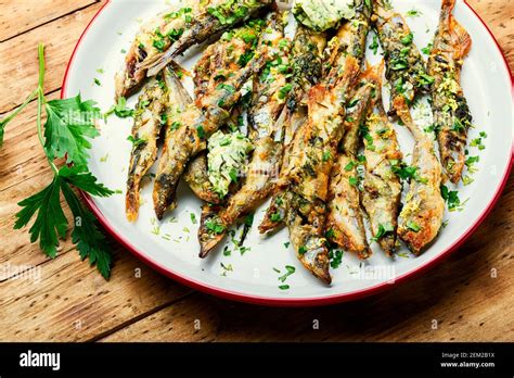 Roasted capelin fish with herbs.Fried capelin fish on plate Stock Photo ...