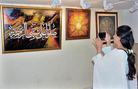 Female visitor capture painting in mobile during Quranic calligraphy exhibition at Arts Council.