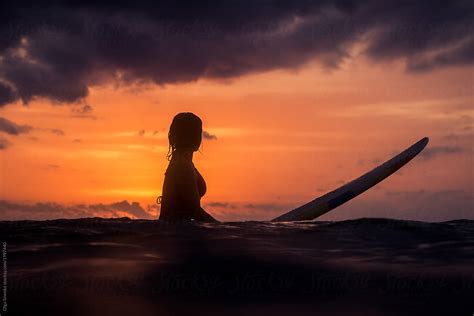 "Woman's Silhouette, Sunset Surf In Bali" by Stocksy Contributor "Olga Sinenko" - Stocksy