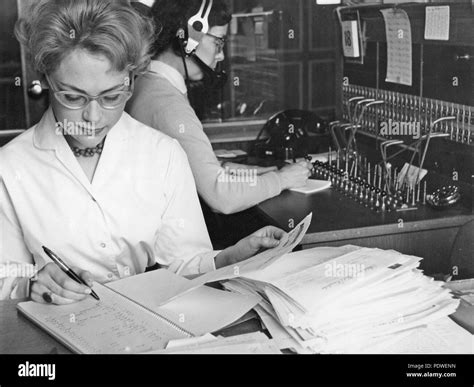 1950s office clerk and telephone switchboard operator. A young office worker is sitting at her ...