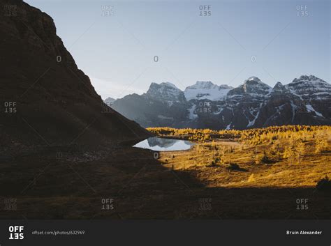 Sunrise over snowy mountain and lake stock photo - OFFSET