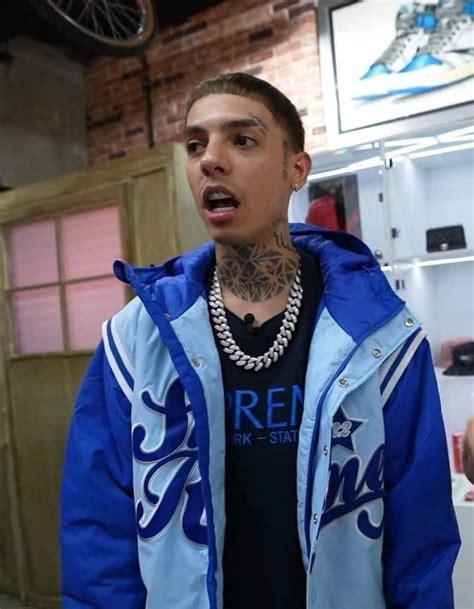 a man with tattoos wearing a blue and white jacket