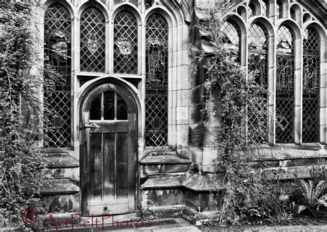 black and white photograph of an old building with ivy growing on the windows, door and side ...