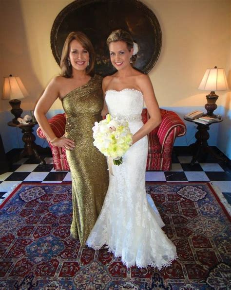 two beautiful women standing next to each other in front of a rug and table with flowers