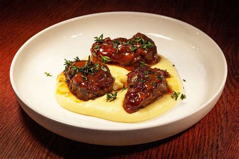 Cider braised pig cheeks with baked potato mash by Tom Simmons - Porc Blasus