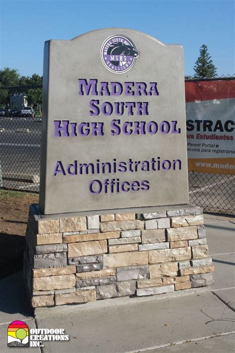 Precast concrete monument sign with base. Base features a rock veneer. Sign has cast in school ...