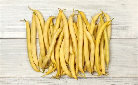 Premium Photo | Yellow string (wax) beans on white boards. tabletop view.