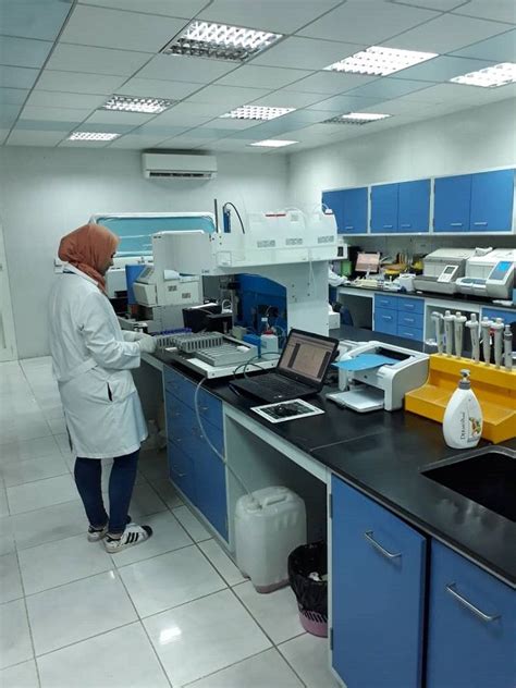 a woman in a lab coat is looking at the computer screen