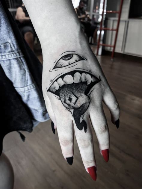 a woman's hand with a black and white tattoo on it