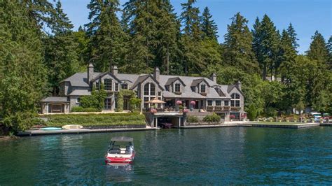 a boat is in the water near a large house with trees on both sides of it