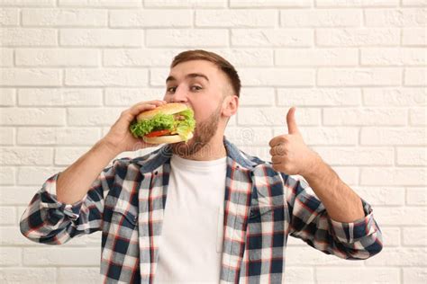 Young Man Eating Tasty Burger Stock Photo - Image of fast, diet: 140211616