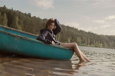 Woman in Black Hoodie in Teal Canoe in Body of Water · Free Stock Photo