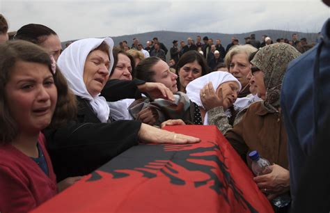 Kosovo Albanians mourn during a reburial ceremony of the remains of 19 ...