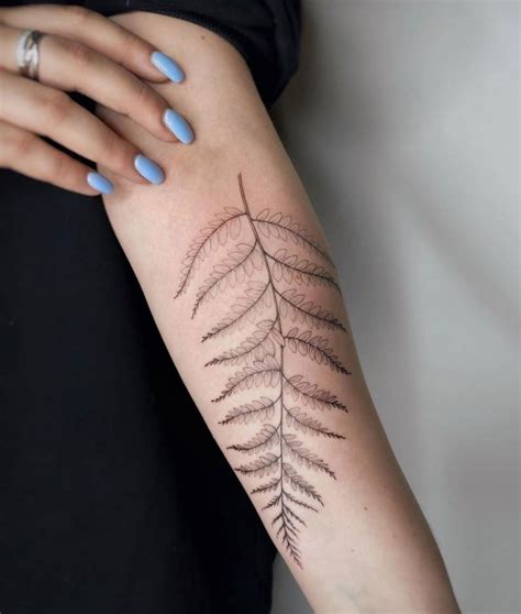 Fern leaf tattoo located on the inner forearm.