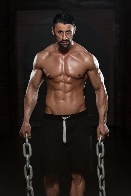 Premium Photo | Portrait Of A Physically Fit Man Showing His Well Trained Body And Holding Chains