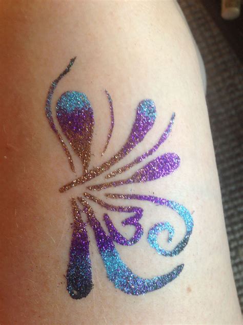 a colorful tattoo on the back of a woman's arm, with glitters all over it