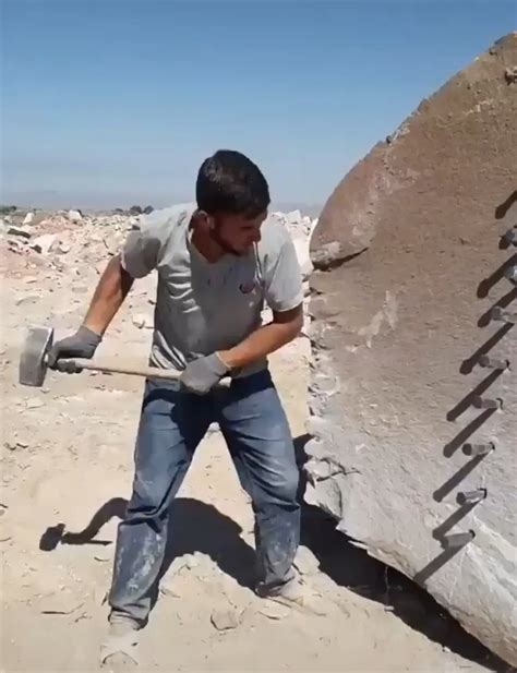 Man splitting a huge rock open with a hammer and some stakes : r/HumansAreMetal