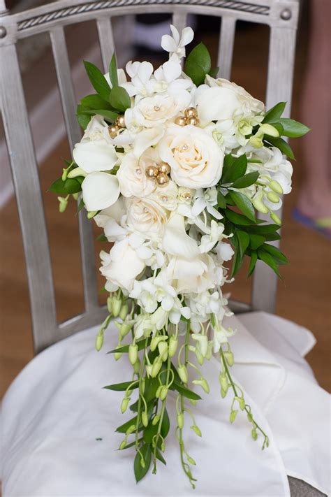 Calla lilies with roses and orchids in a cascade bouquet. Bride bouquet with gold assents ...