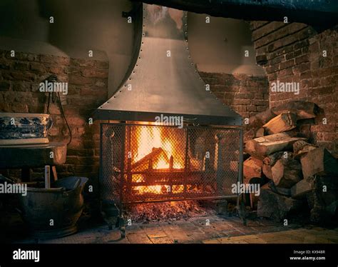 Traditional Inglenook fireplace with roaring log fire Stock Photo - Alamy