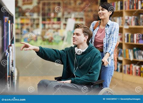 Boy in Wheelchair Choosing Book Stock Image - Image of bookstore, adult: 144238947