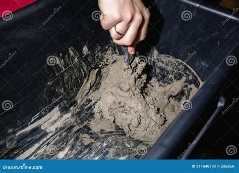 A Person Mixes Cement and Water in a Container To Get the Finished ...