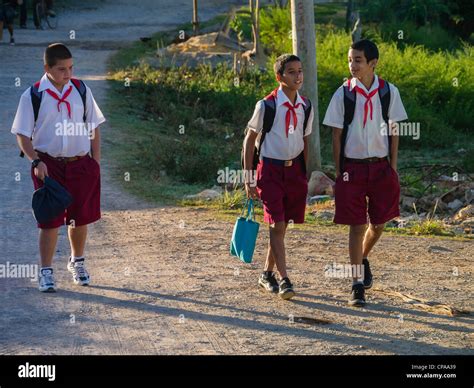 Three young Cuban school boys walk home from school in their school uniforms in Viñales, Cuba ...