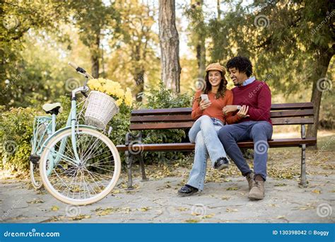 Multiratial Loving Couple Sitting on Bench in the Autumn Park Stock Photo - Image of friends ...