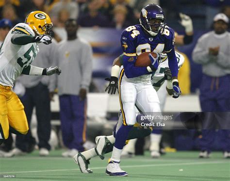 Randy Moss of the Minnesota Vikings carries the ball as Tyrone... News ...