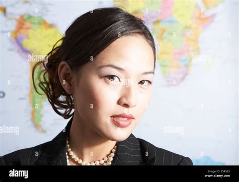 Chinese businesswoman standing by world map Stock Photo - Alamy