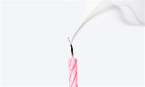 Premium Photo | Candle with smoke blown out on white background.