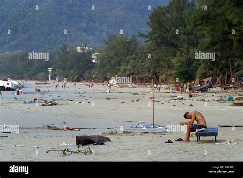 Un homme est assis seul sur la plage de Patong, l'île de Phuket, Thaïlande le jour après le ...