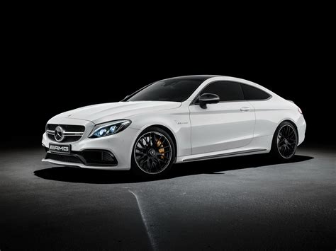 the front end of a white mercedes s - class coupe in a dark room with its lights on