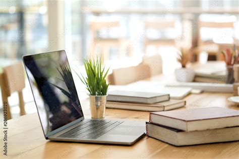 Desk with laptop, books and business office background. Stock Photo | Adobe Stock
