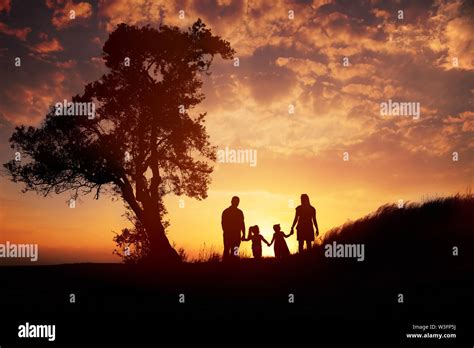 Happy family silhouette standing on against sunset time Stock Photo - Alamy