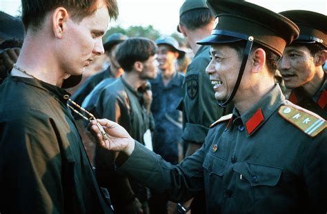 A North Vietnamese Army officer laughs at the peace symbol necklace of ...