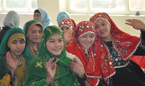 Hazara girls wearing red traditional hijabs sitting next to Tajik and ...