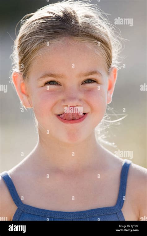 Girl touching nose with tongue Stock Photo - Alamy