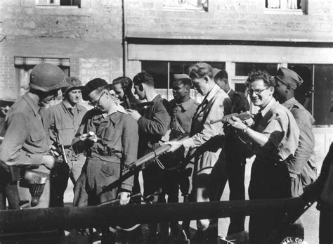 Members of the French Resistance and American troops compare weapons